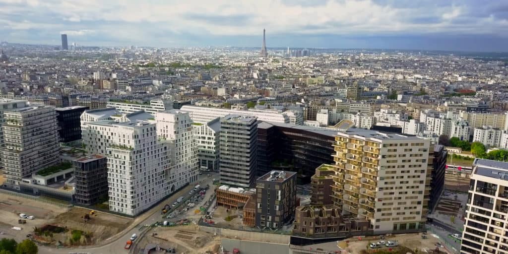 Vue aérienne d'un quartier parisien en construction pour TERIDEAL, Tour Eiffel à l'horizon