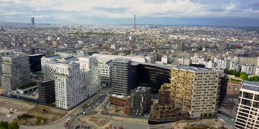 Vue aérienne d'un quartier parisien en construction pour TERIDEAL, Tour Eiffel à l'horizon