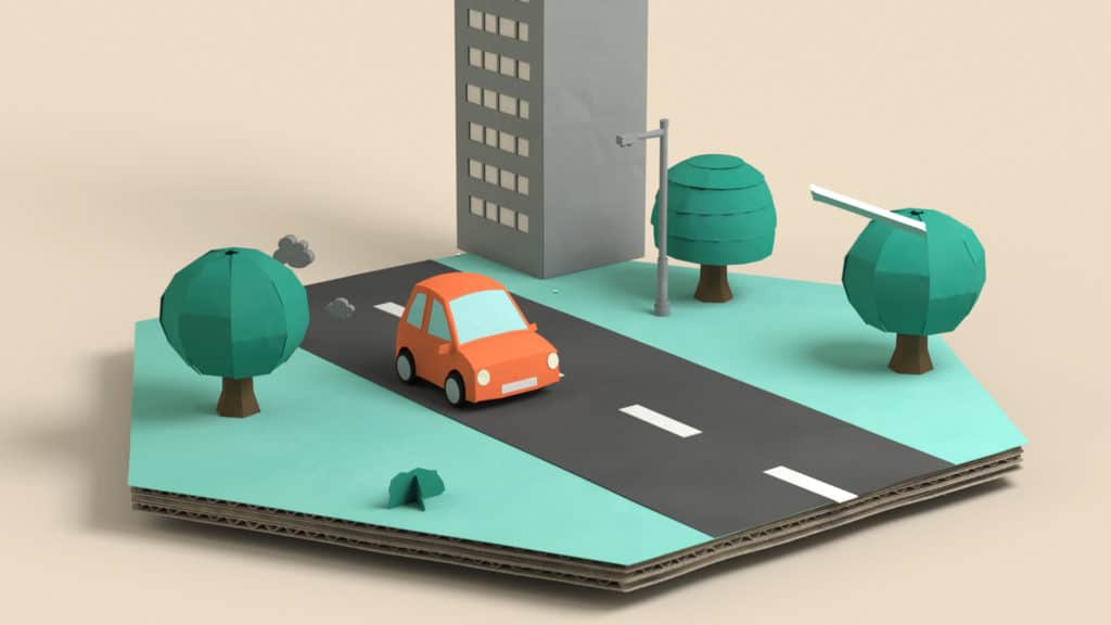 Voiture orange sur une route bordée d’arbres, décor 3D en carton, film Fuel For Planet