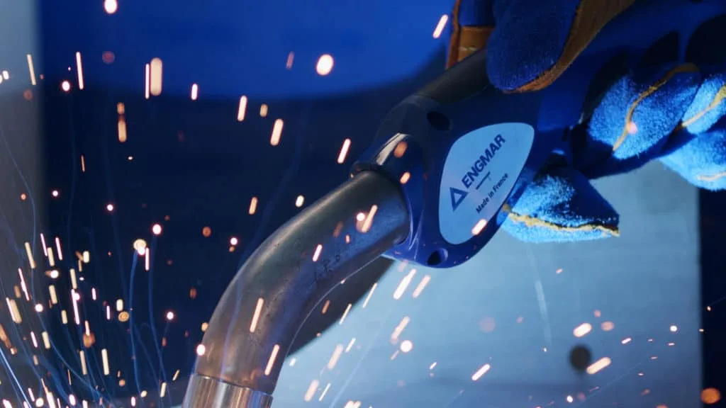 Torche de soudage ENGMAR dans un gant bleu, au milieu des étincelles