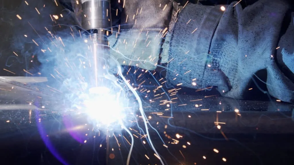 Arc de soudure bleu et gerbe d’étincelles en gros plan, film institutionnel ENGMAR