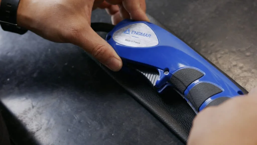 Main sur la poignée bleue d’une torche ENGMAR marquée « Made in France »