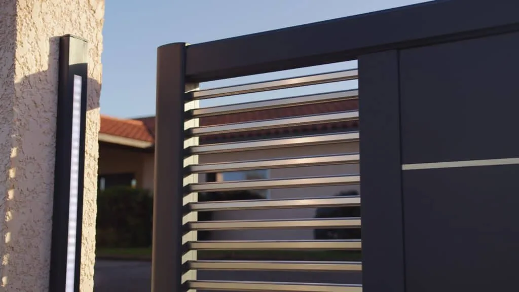 Portail aluminium CEBEL et son éclairage intégré à la tombée du jour, spot TV