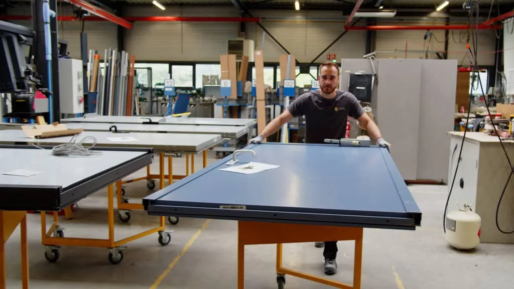 Assemblage d’une porte métallique sur table dans l’atelier Doortal