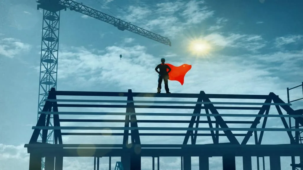 Silhouette d’ouvrier en cape de super-héros debout sur une charpente, campagne de prévention FFB