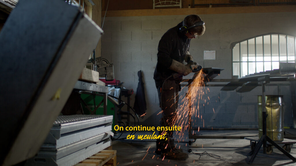 Meulage d'une pièce métallique, gerbe d'étincelles — atelier de métallerie