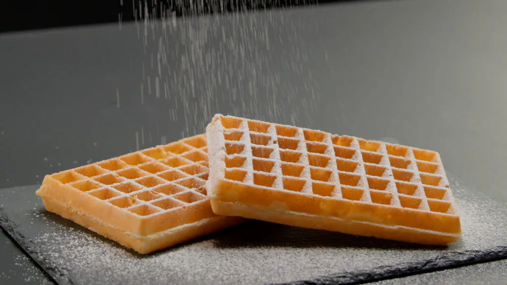 Sucre glace tombant sur deux gaufres dorées, film de lancement Lagrange